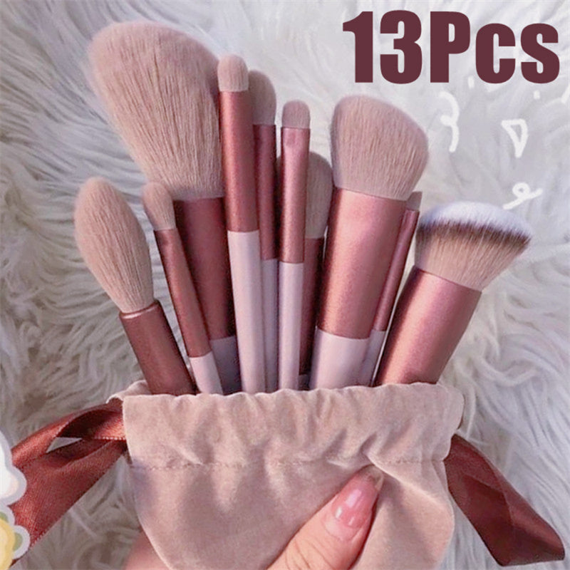 13Pcs Makeup Brush Set with pink bristles and rose gold handles in a velvet pouch, ideal for foundation, blush, and eyeshadow application.