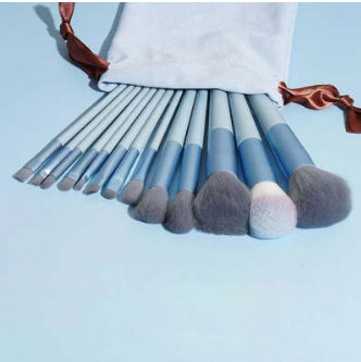 13Pcs Makeup Brush Set with blue handles and soft synthetic bristles, includes foundation, blush, concealer, and eyeshadow brushes with storage pouch.