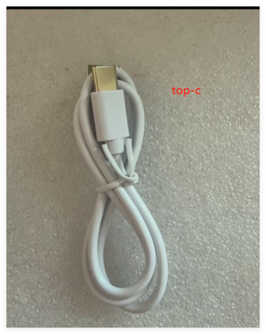 Close-up of USB charging cable for Neck Lifting Skin Massager Device for Anti-Aging Benefits, shown coiled on a flat surface.