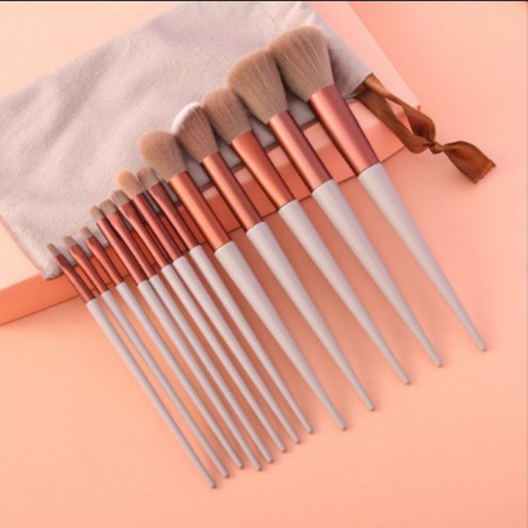 13Pcs Makeup Brush Set with white handles and rose gold ferrules, includes full range of cosmetic brushes with soft bristles and velvet pouch.