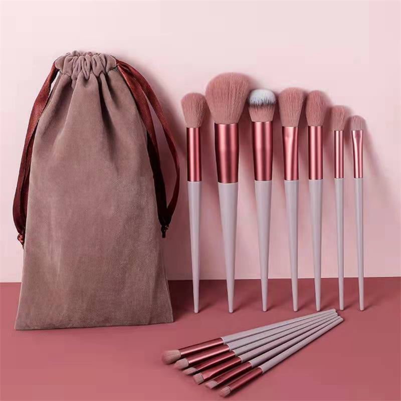 13Pcs Makeup Brush Set displayed with soft pink bristles and sleek handles, includes pouch for storing foundation, blush, and eye brushes.